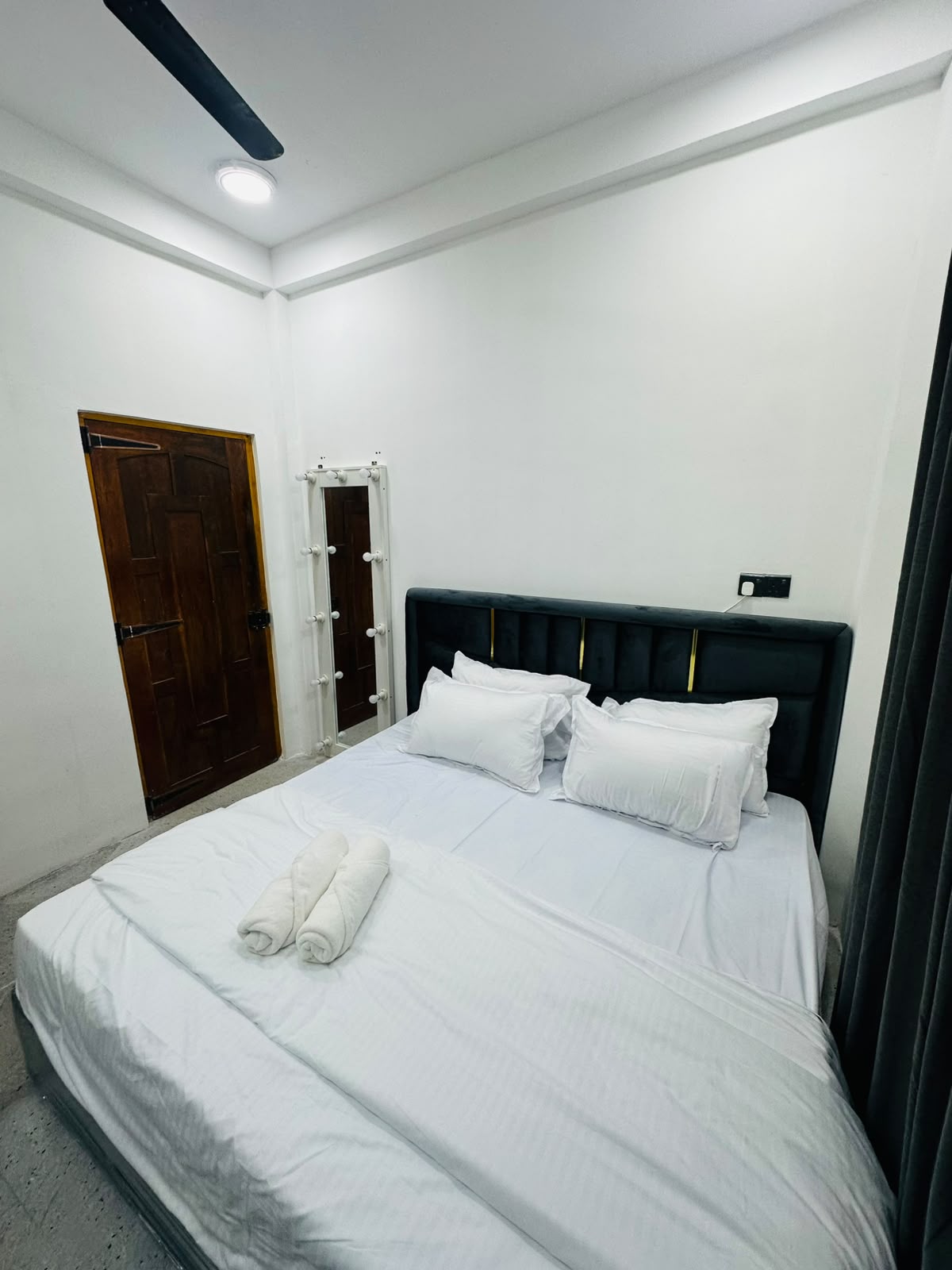 Bedroom with bed, wooden door, and monochrome decor