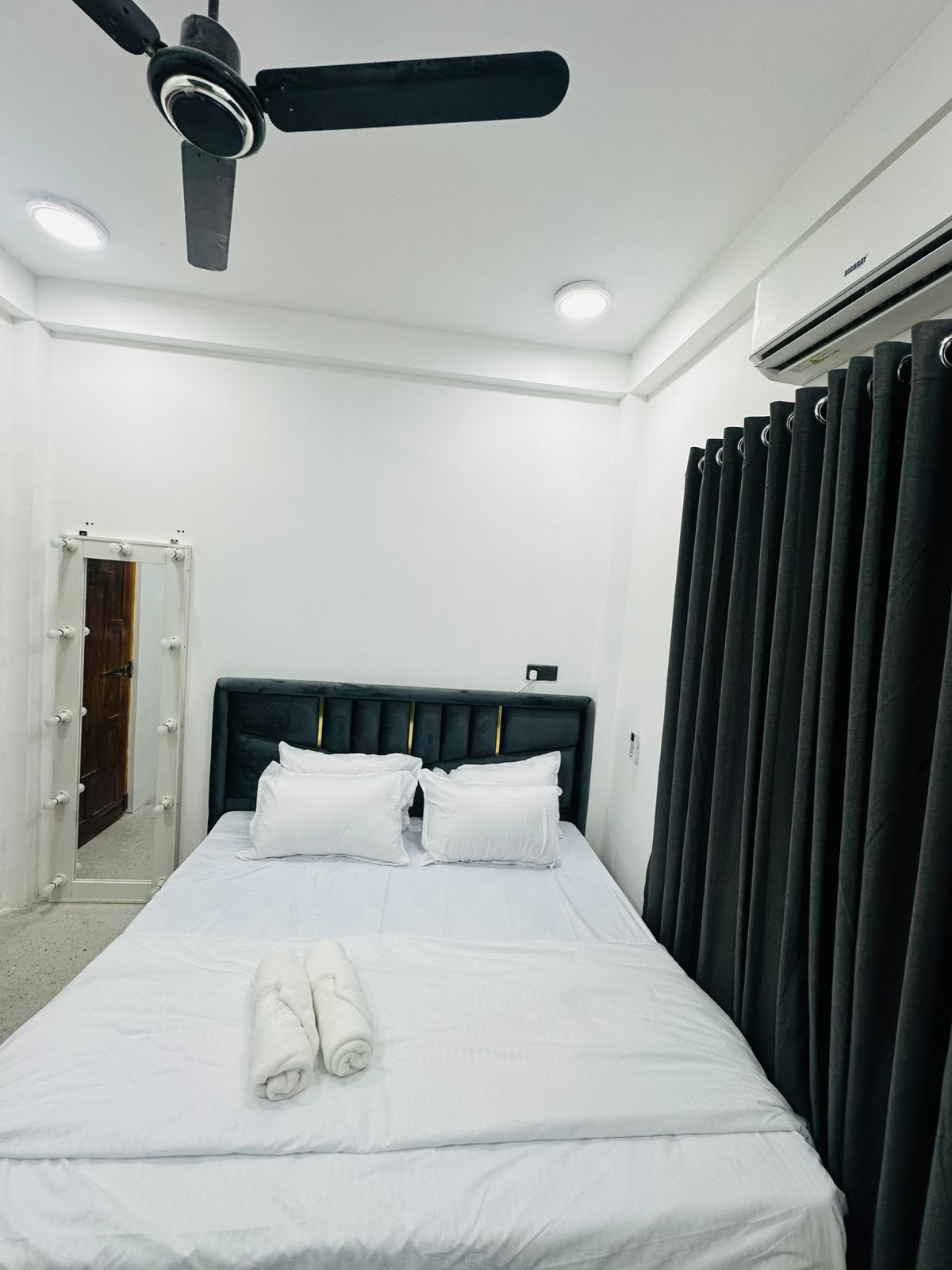 Bedroom showing full bed frame and side furnishings