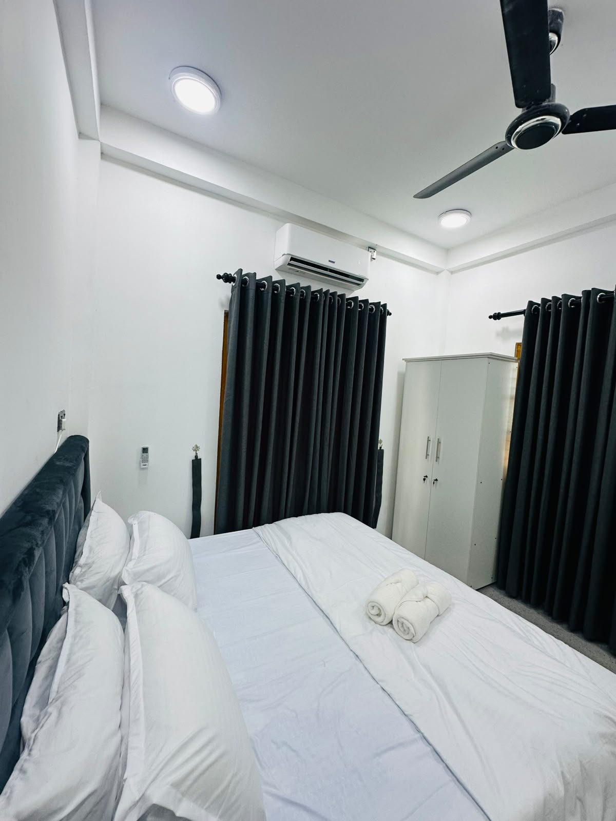 Bedroom with double bed set against dark curtains
