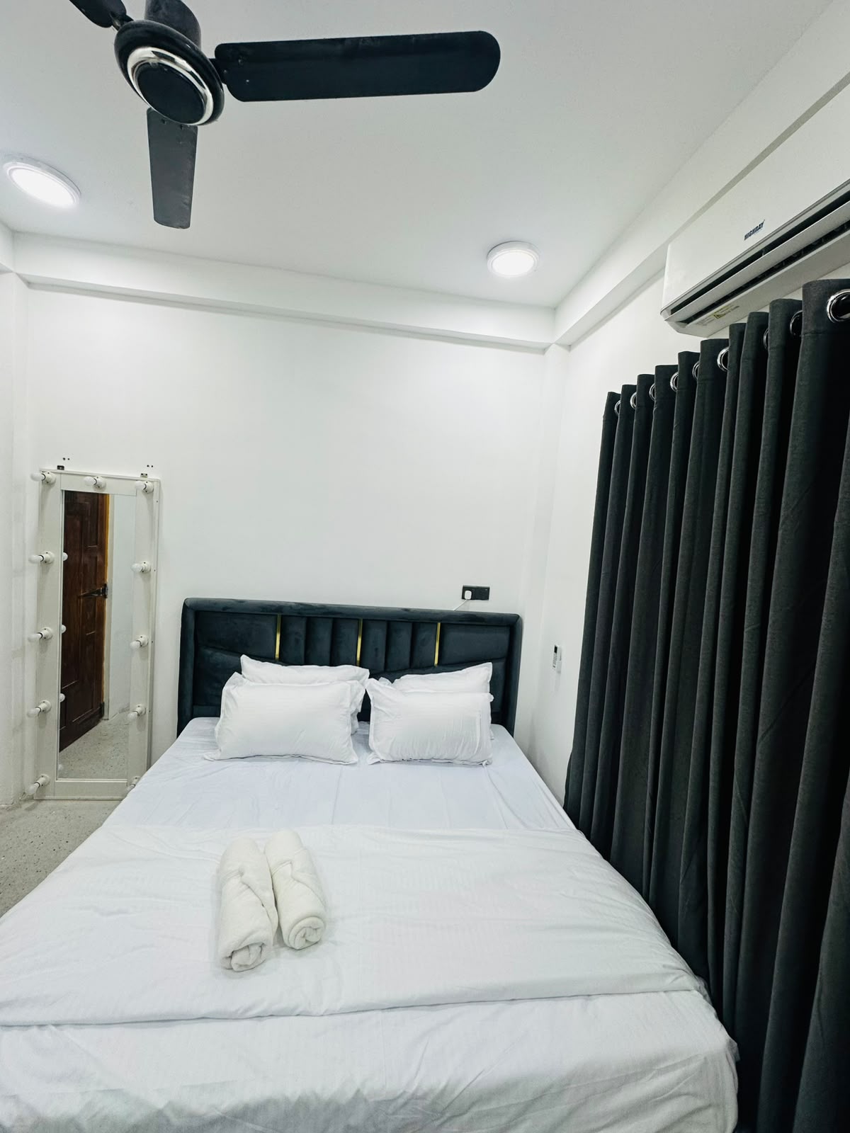 Bedroom photographed from the doorway with bedside furnishings