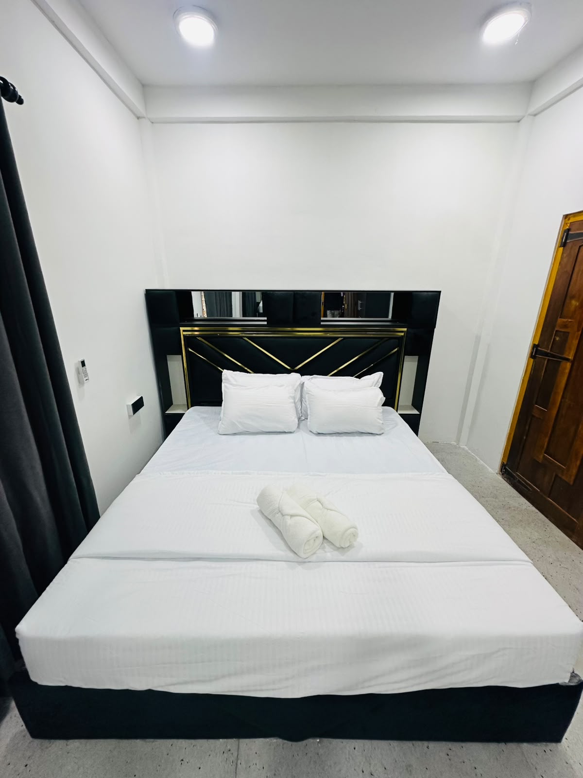 Bedroom wide shot with bed, mirror, and open floor space